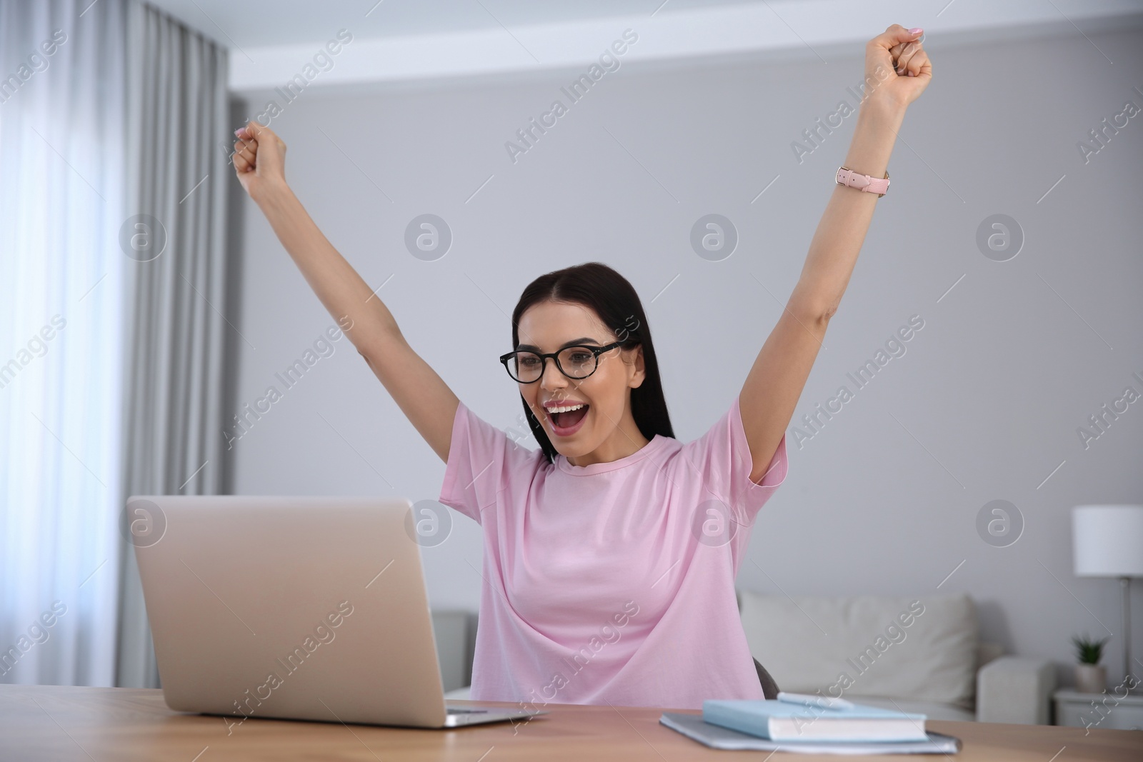 Photo of Emotional woman participating in online auction using laptop at home