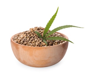 Wooden bowl of hemp seeds and leaf on white background
