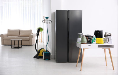 Photo of Refrigerator and different household appliances in room