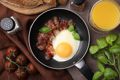 Photo of Fried egg and bacon served on brown table, top view