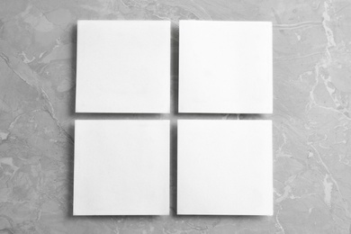 Photo of Blank note papers on light grey marble background, flat lay. Mock up for design
