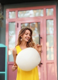 Photo of Happy young woman with cotton candy outdoors