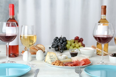 Photo of Wine and snacks served for dinner on table at home