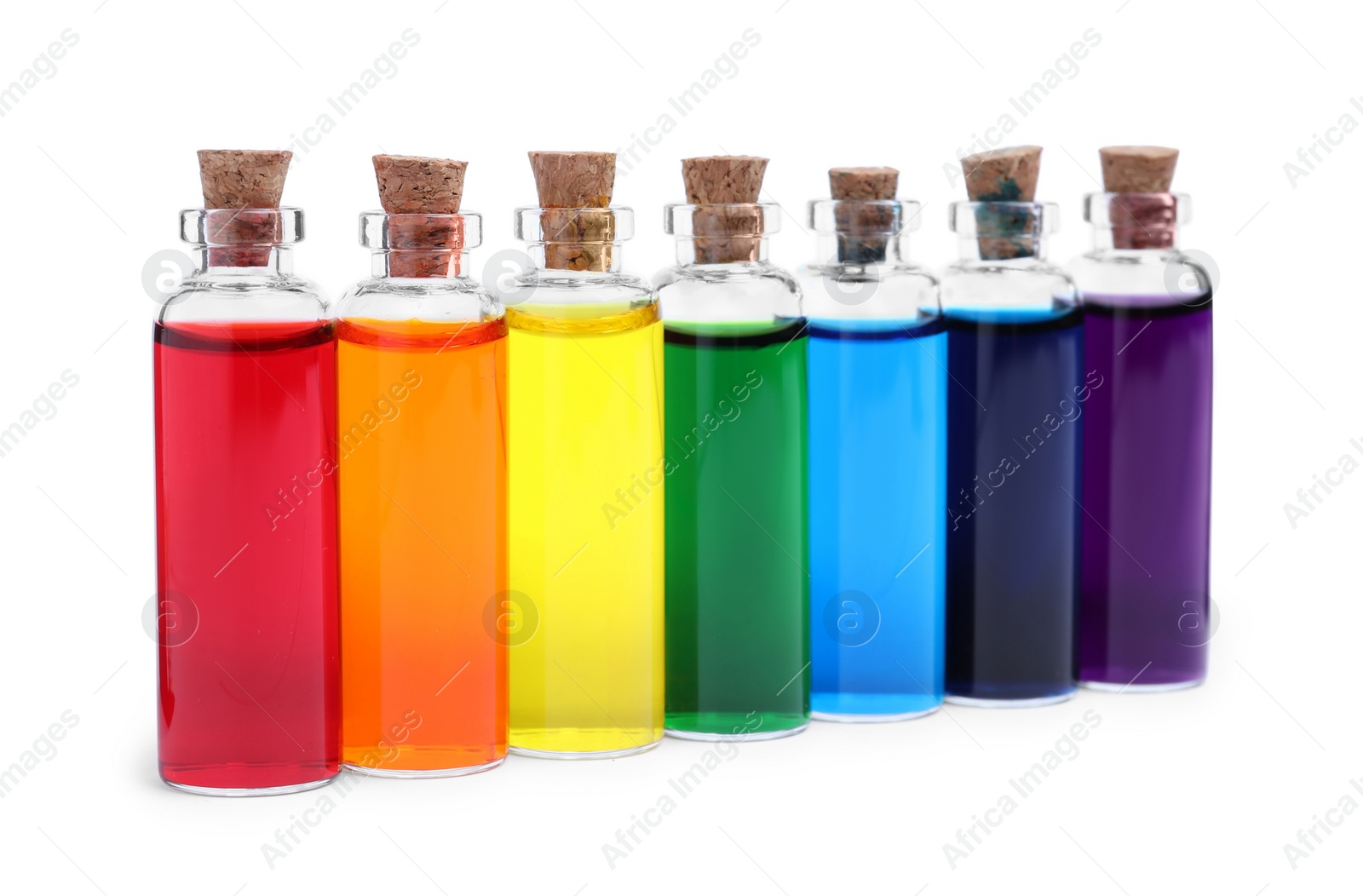 Photo of Glass bottles with different food coloring on white background