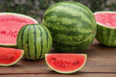 Photo of Delicious whole and cut watermelons on wooden table