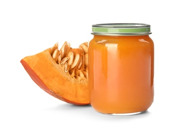 Jar with healthy baby food and pumpkin slice on white background