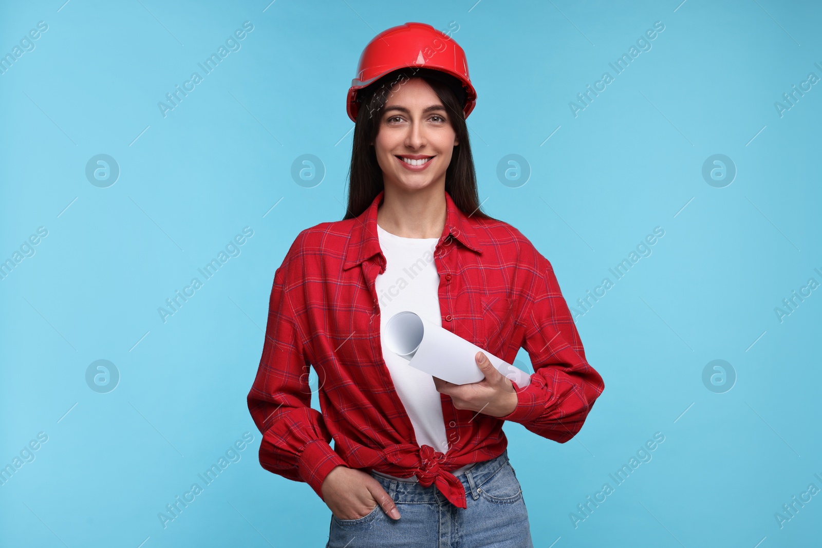 Photo of Architect in hard hat with draft on light blue background