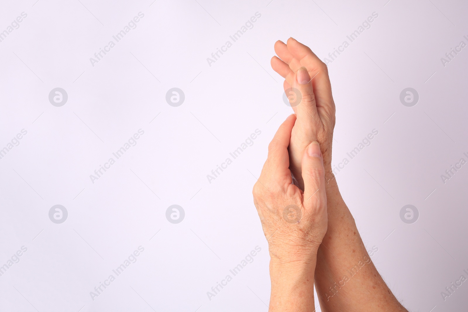 Photo of Closeup view of older woman's hands on white background. Space for text