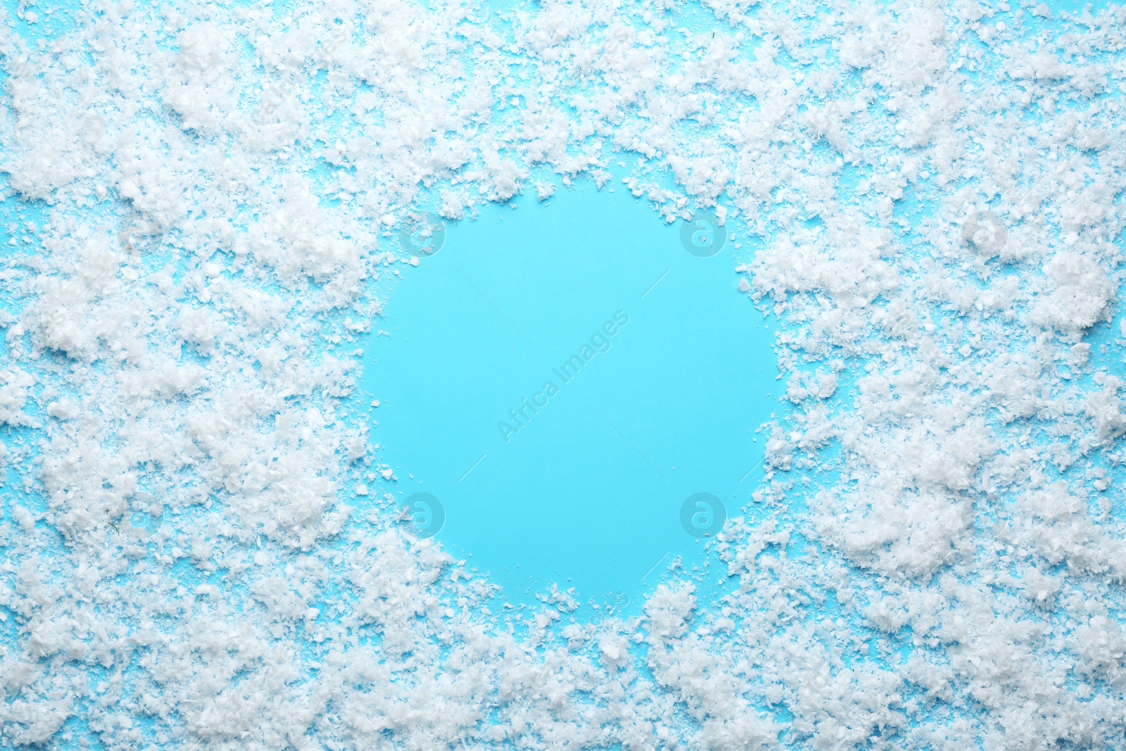 Photo of Frame made of snow on blue background, top view with space for text. Winter season