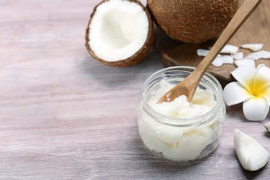 Photo of Beautiful composition with coconut oil and nuts on wooden background