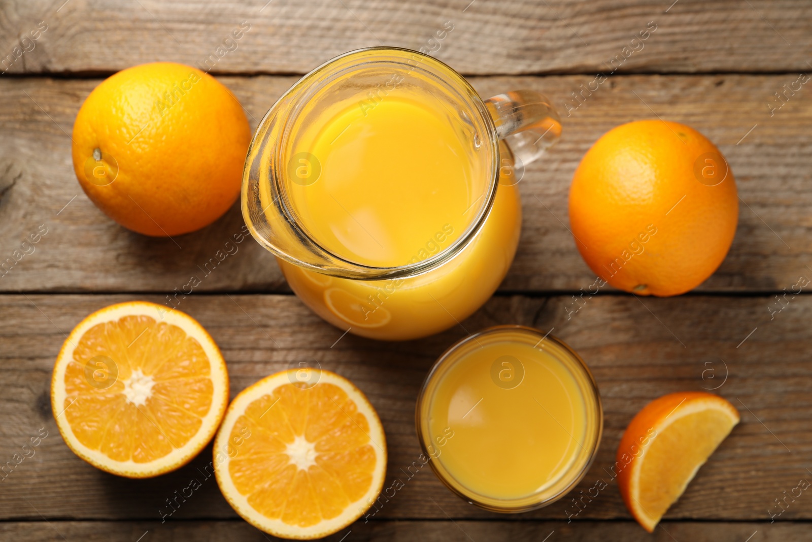 Photo of Tasty fresh oranges and juice on wooden table, flat lay