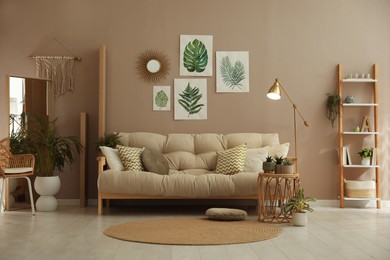 Stylish living room interior with comfortable sofa and beautiful pictures on wall