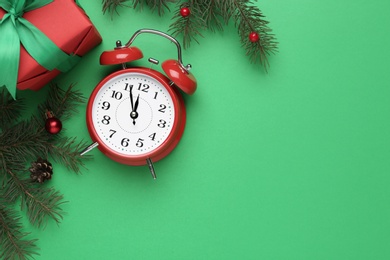 Photo of Flat lay composition with Christmas gift and alarm clock on green background, space for text. Boxing day