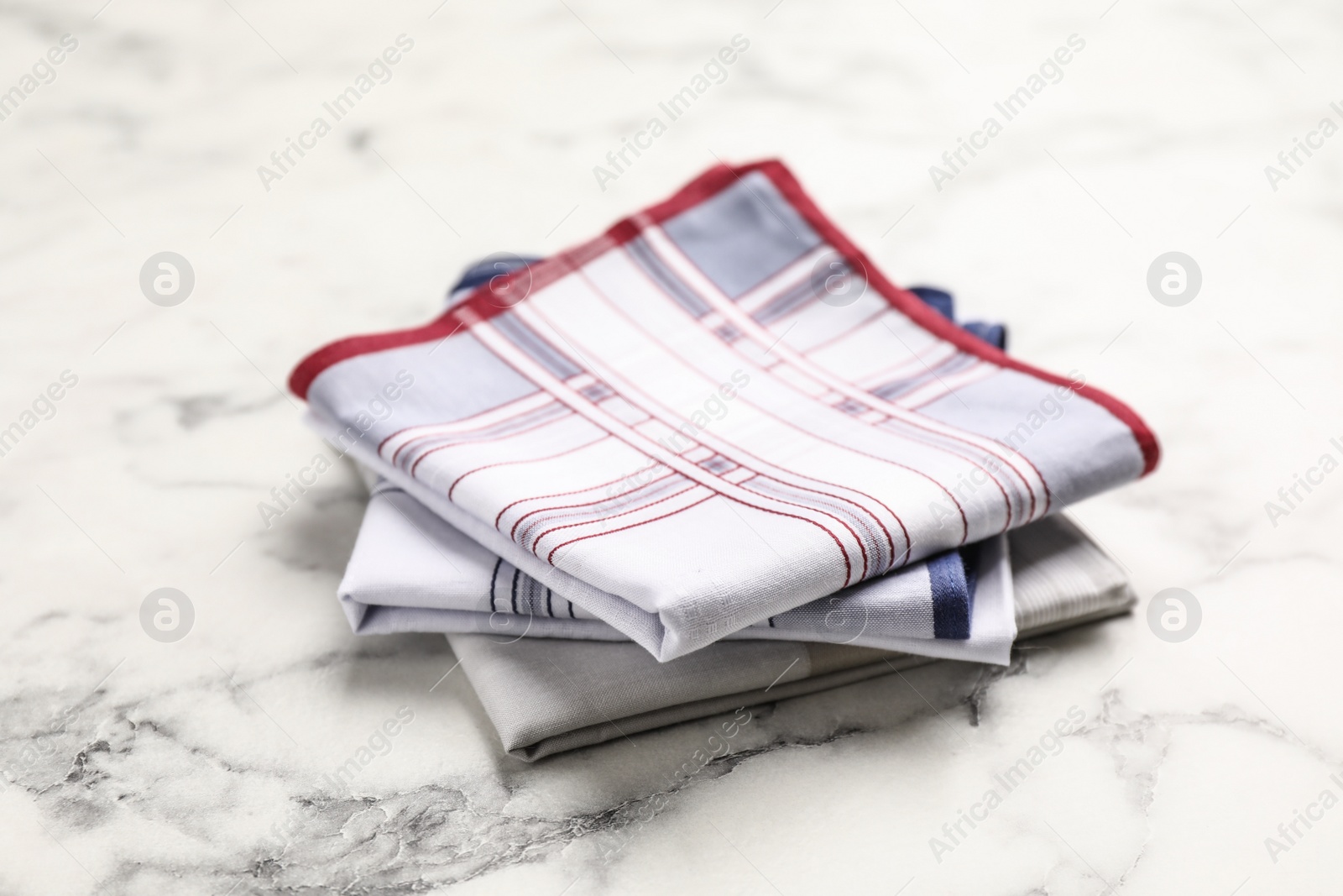 Photo of Different handkerchiefs folded on white marble table