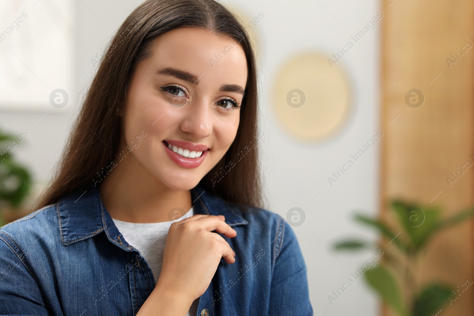 Photo of Portrait of beautiful young woman indoors, space for text. Attractive lady smiling and looking into camera