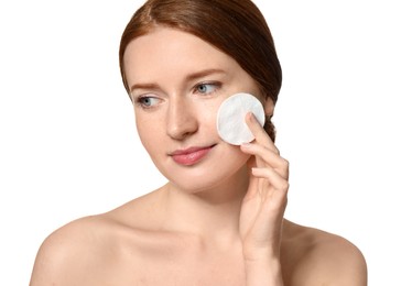 Beautiful woman with freckles holding cotton pad on white background