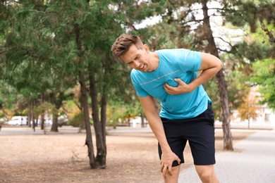 Young man having heart attack while running in park