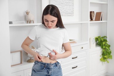 Photo of Diabetes. Woman making insulin injection into her belly at home, space for text