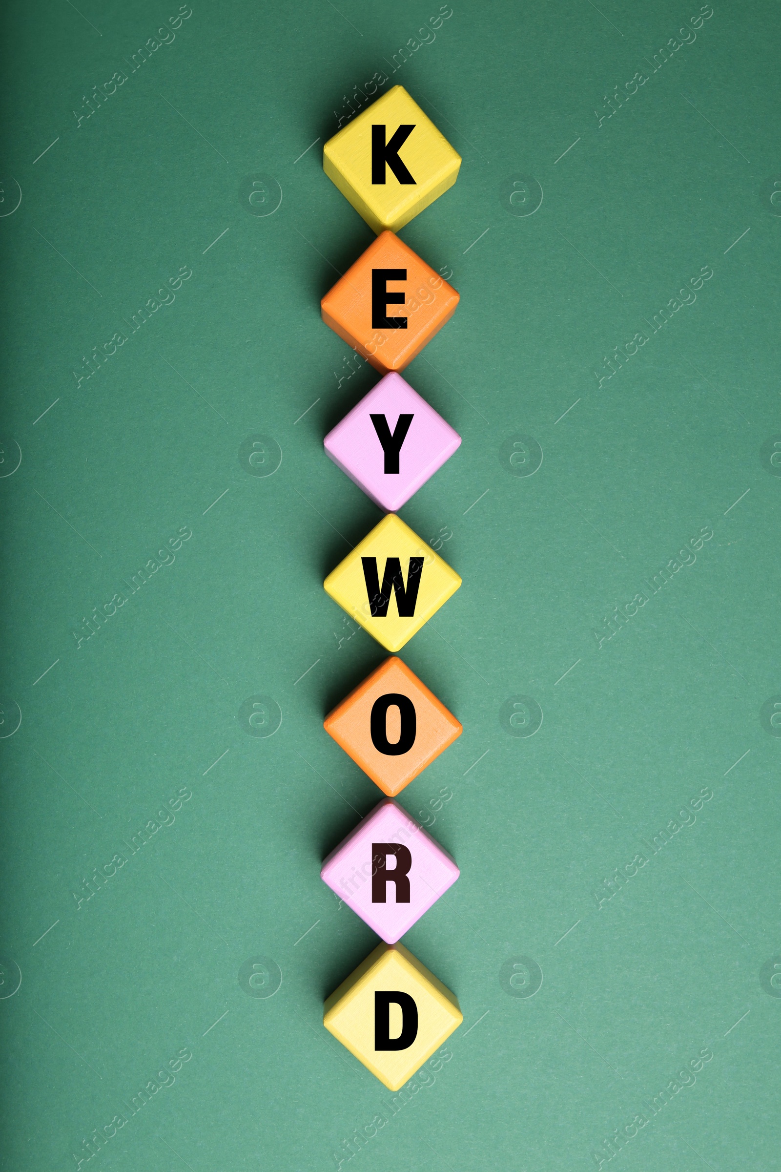 Photo of Colorful cubes with word KEYWORD on green background, flat lay