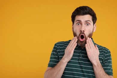 Photo of Portrait of surprised man on yellow background, space for text