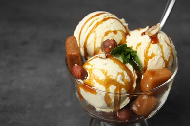 Photo of Delicious ice cream served with caramel and sauce on table, closeup. Space for text