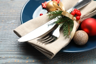 Photo of Festive table setting with beautiful dishware and Christmas decor on grey wooden background, closeup