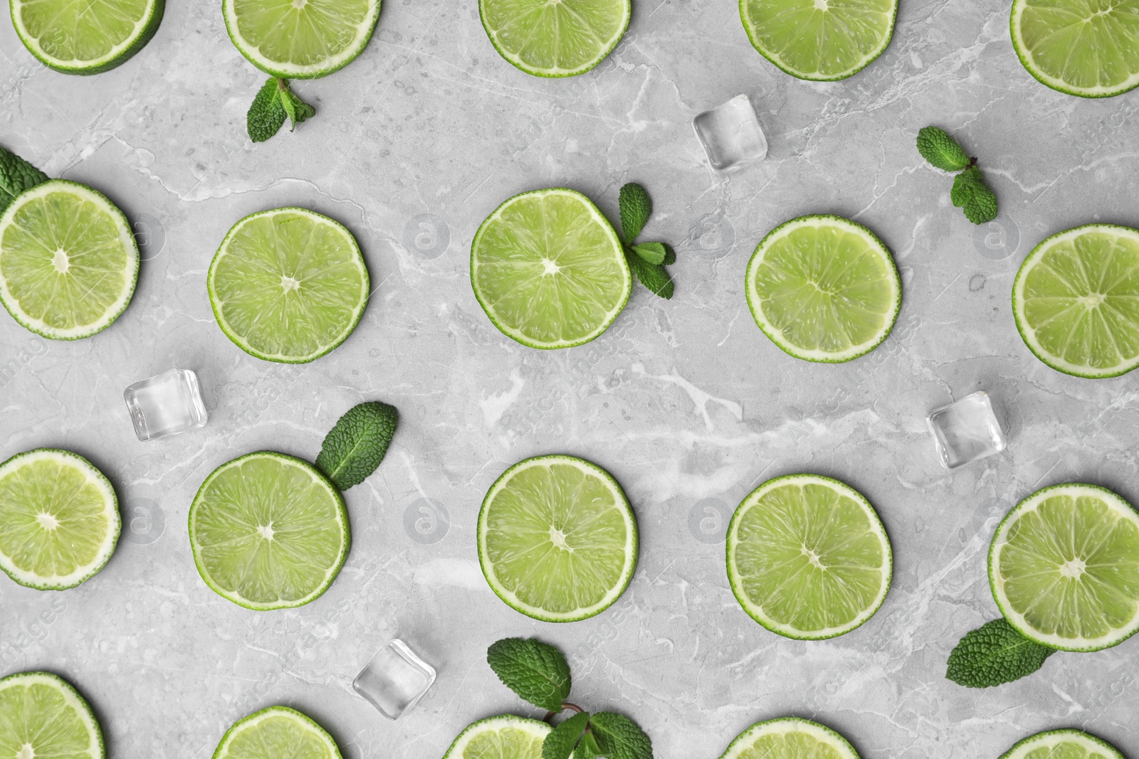 Photo of Flat lay composition with slices of fresh juicy limes on marble table