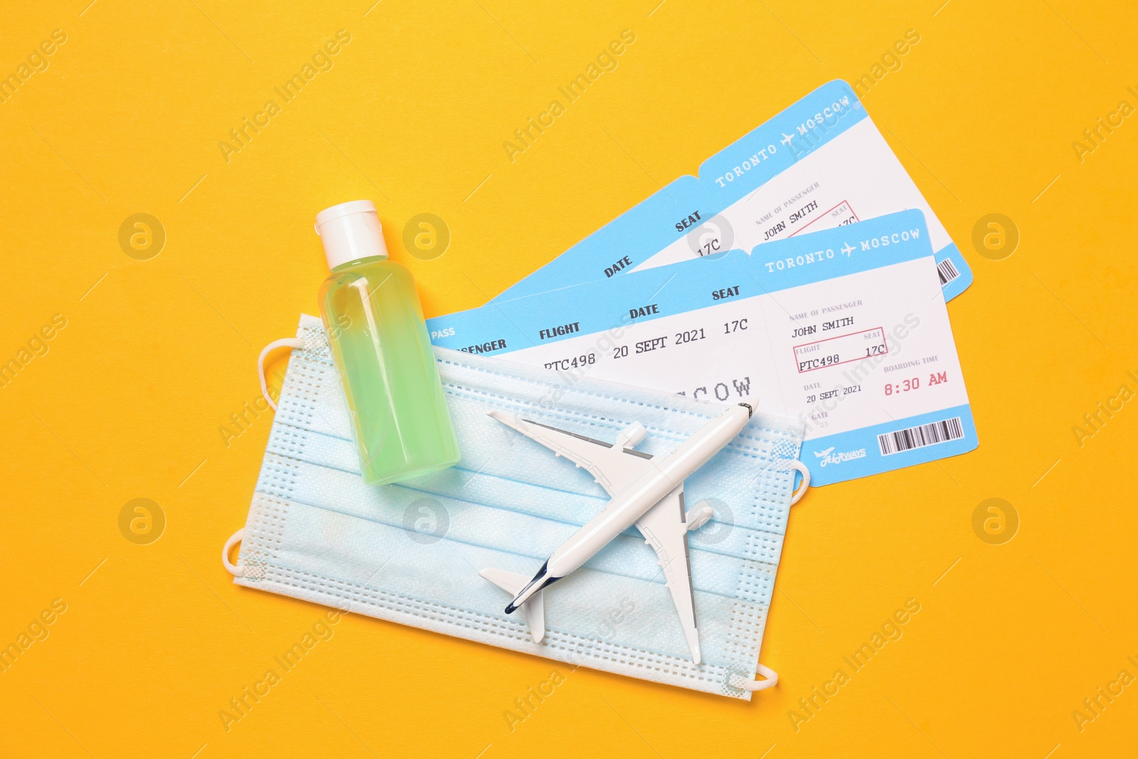 Photo of Flat lay composition with tickets and protective mask on yellow background. Travel during quarantine