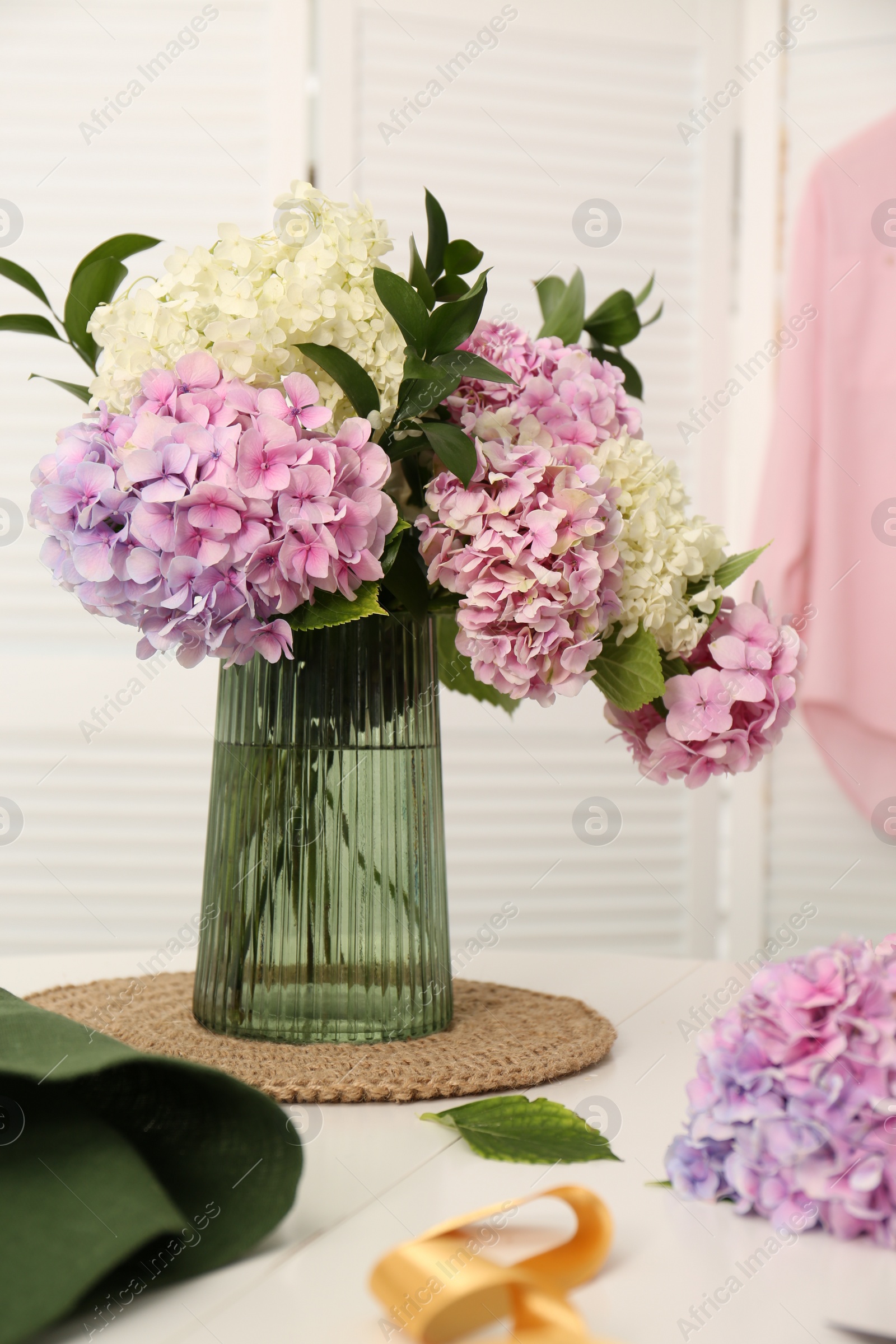 Photo of Bouquet of beautiful hydrangea flowers on white table indoors. Interior design