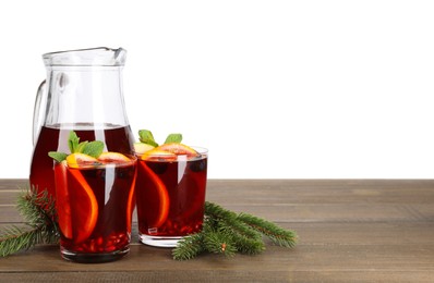 Aromatic Christmas Sangria drink and fir branches on wooden table against white background, space for text