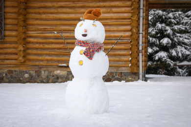 Funny snowman with hat and scarf outdoors. Winter vacation