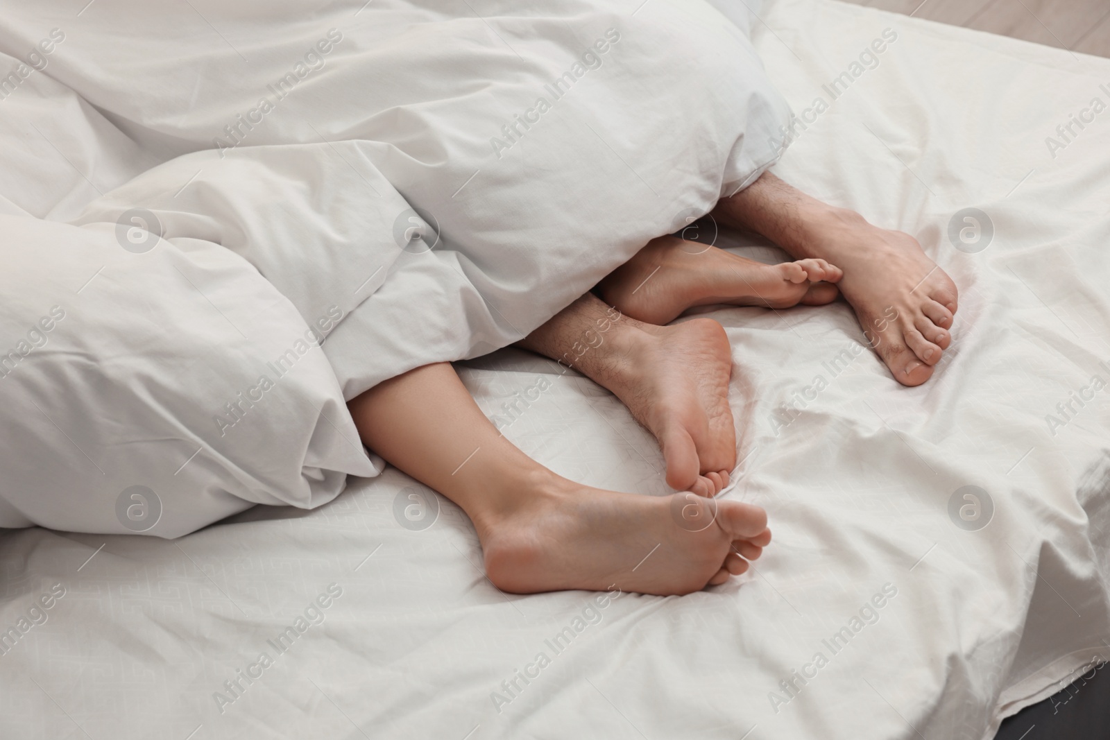 Photo of Passionate couple having sex on bed, closeup of legs