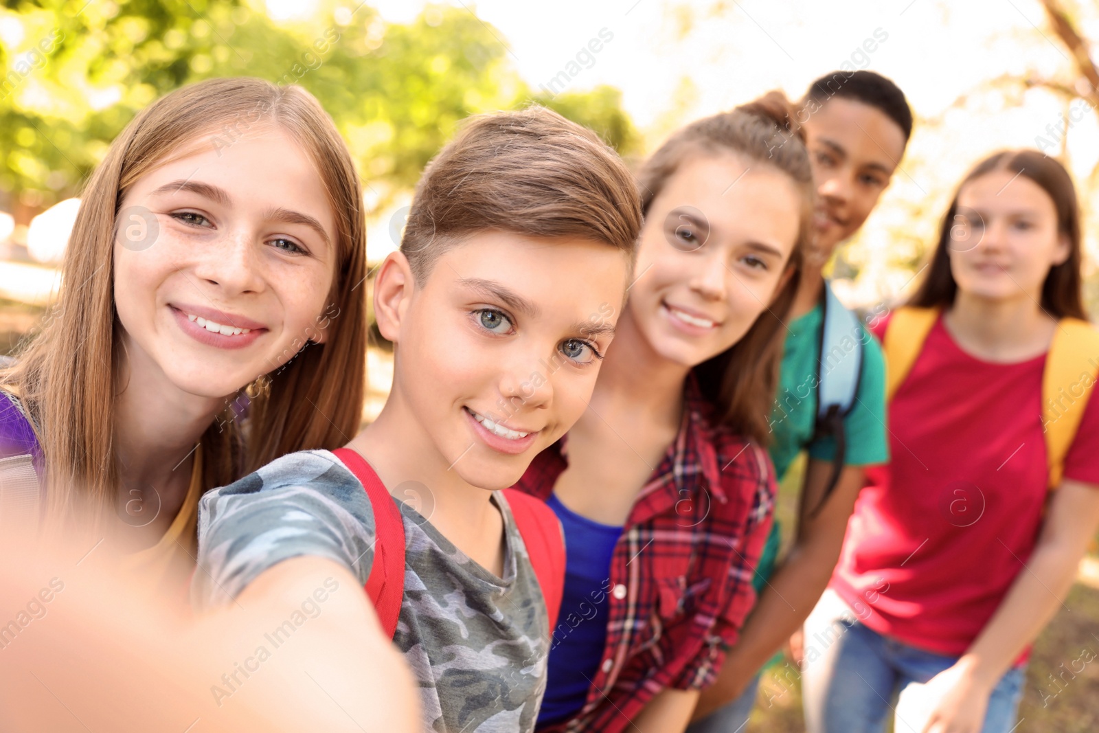 Photo of Group of children taking selfie outdoors. Summer camp