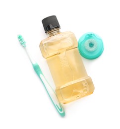 Mouthwash, toothbrush and dental floss on white background, top view