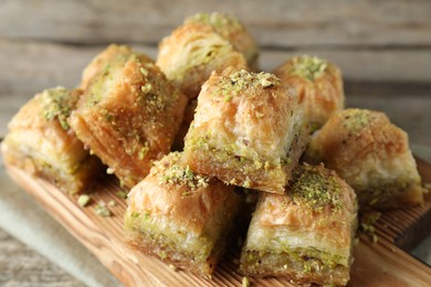 Photo of Delicious fresh baklava with chopped nuts on table, closeup. Eastern sweets