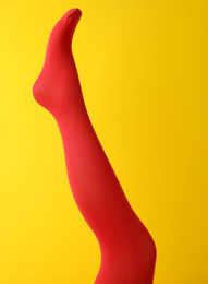 Photo of Leg mannequin in red tights on yellow background