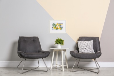 Room interior with modern chairs and table near color wall