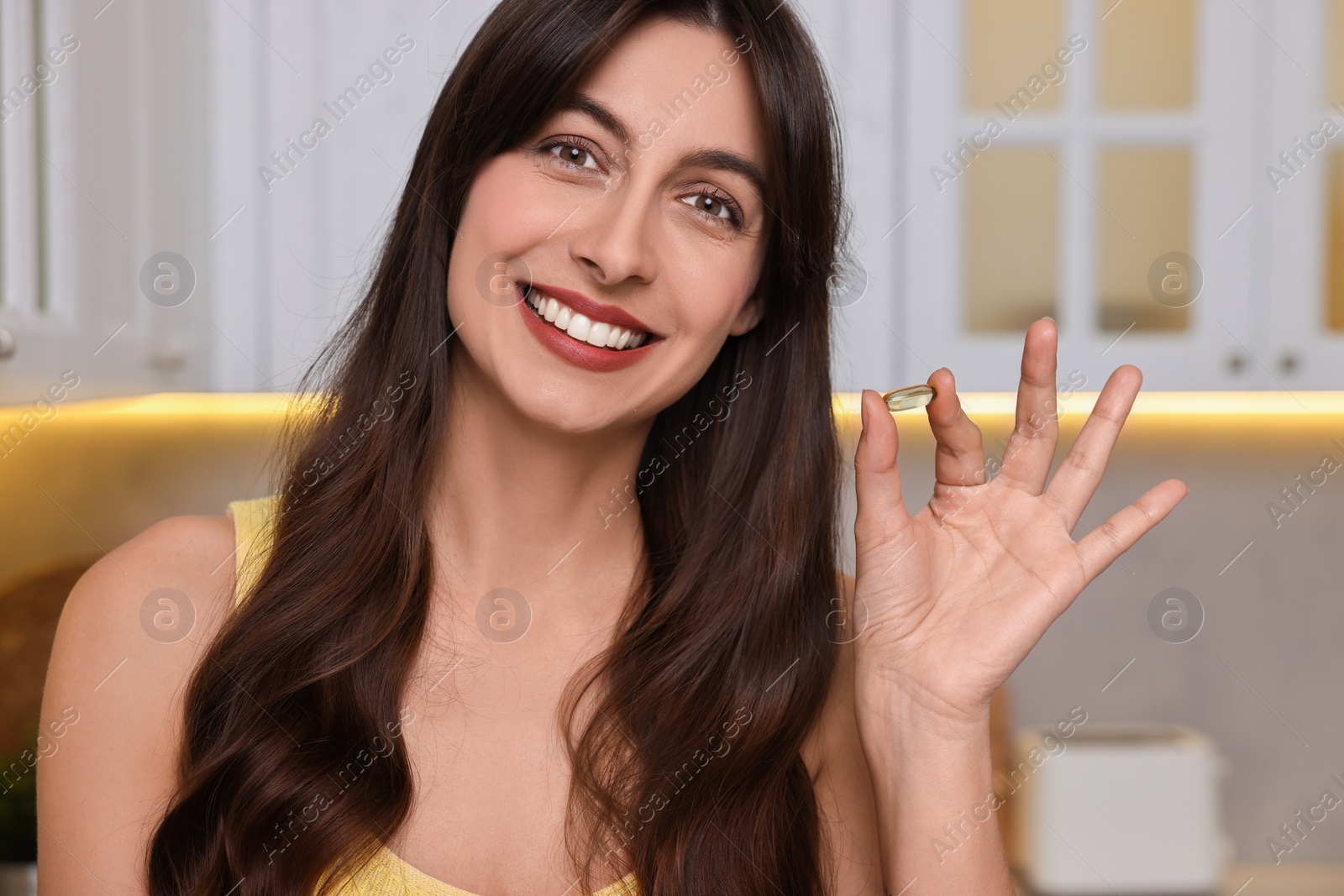 Photo of Beautiful woman with vitamin pill at home