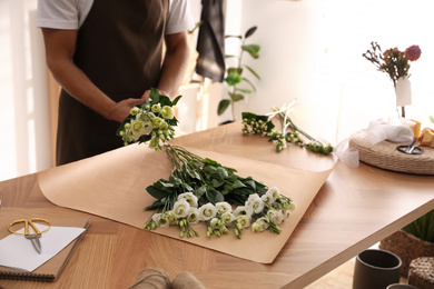 Photo of Florist making beautiful bouquet in workshop, closeup