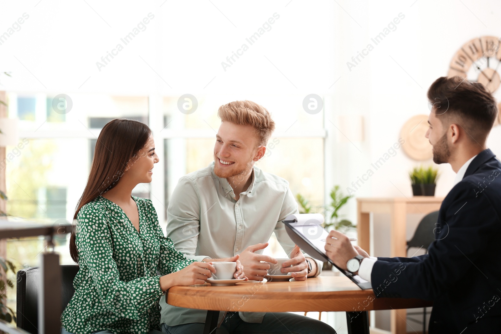Photo of Insurance agent working with young couple in office