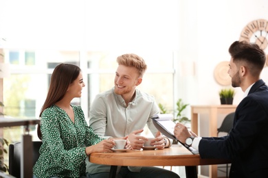 Insurance agent working with young couple in office