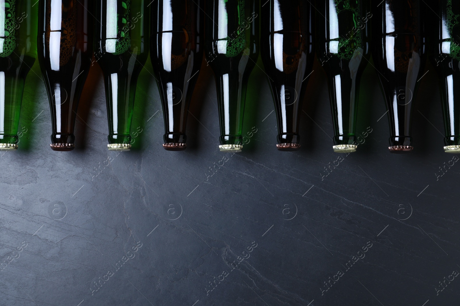 Photo of Bottles of beer on grey table, flat lay. Space for text