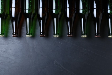 Bottles of beer on grey table, flat lay. Space for text