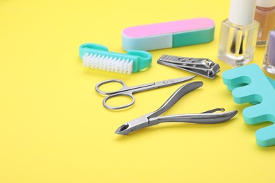 Photo of Set of pedicure tools on yellow background