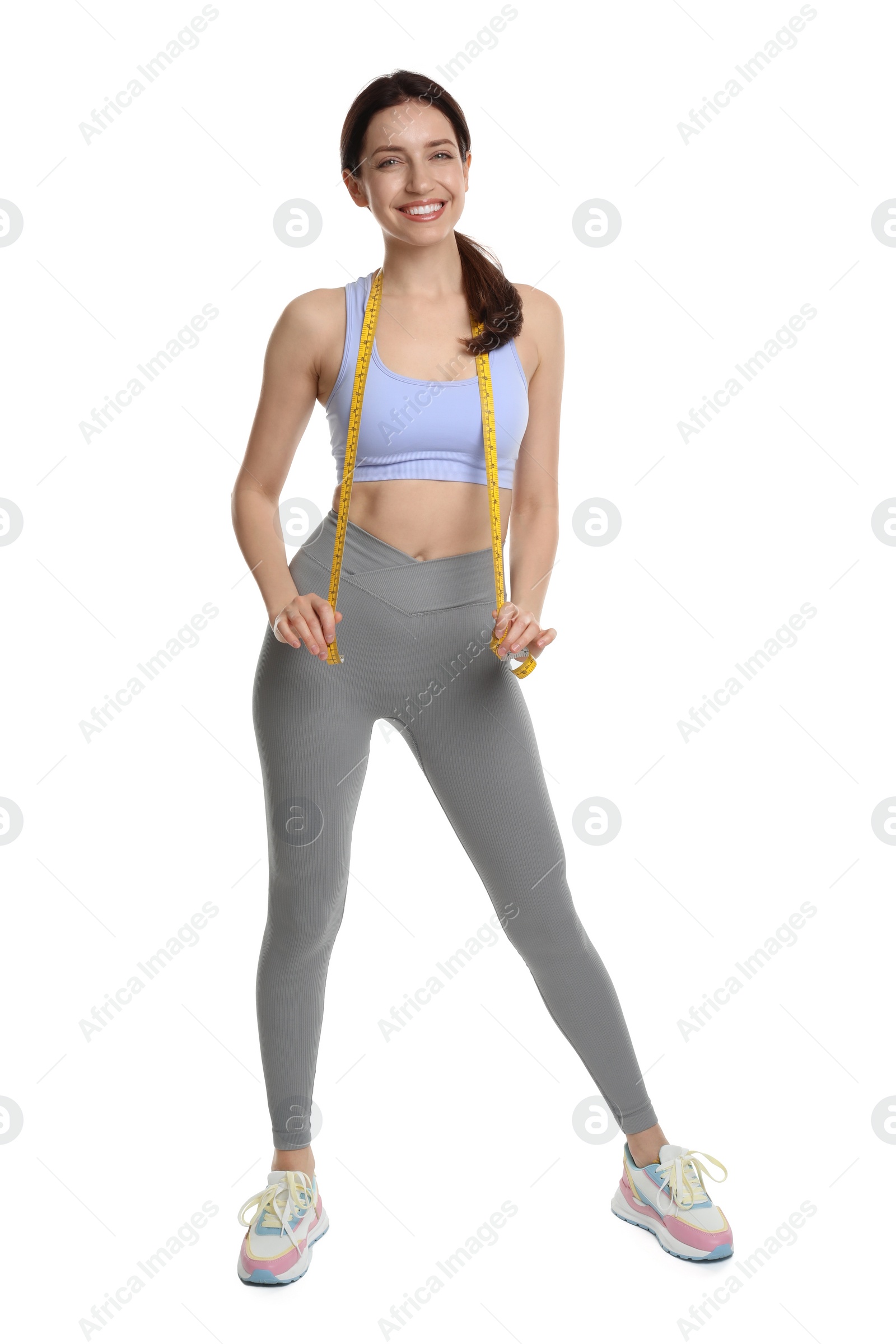 Photo of Happy young woman with measuring tape showing her slim body against white background