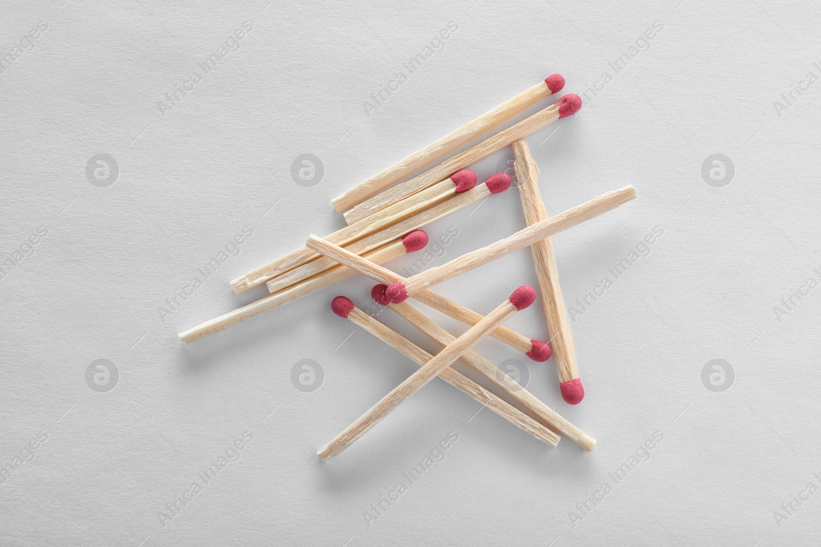 Photo of Pile of wooden matches on white background, top view