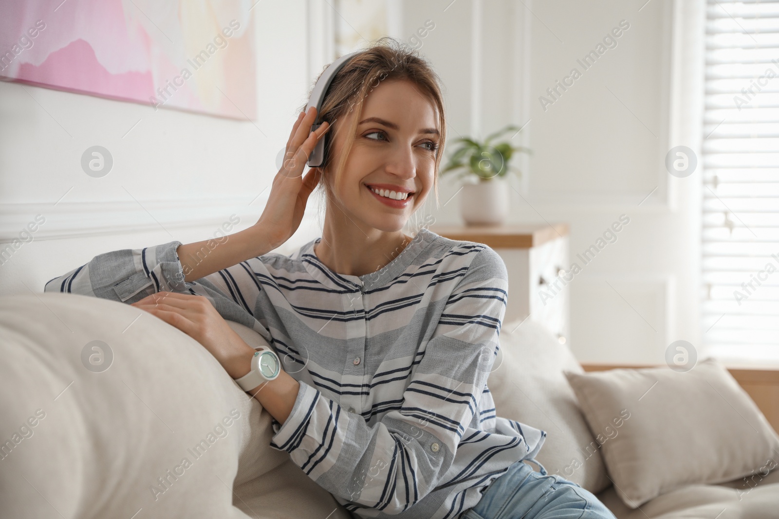 Photo of Young woman listening to music at home