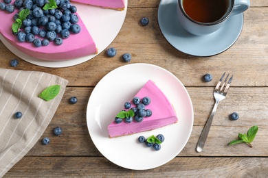 Flat lay composition of tasty blueberry cake on wooden table