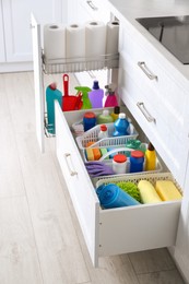 Different cleaning supplies in open drawers indoors