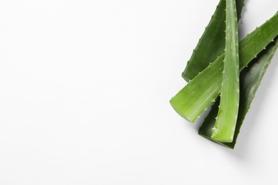 Photo of Green aloe vera leaves on white background, flat lay. Space for text